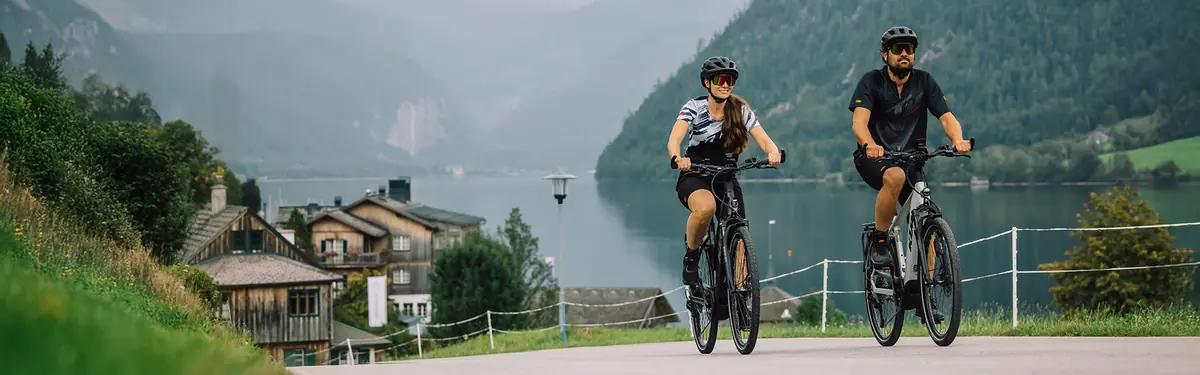 Couple sur e-bikes trekking KTM au bord d'un lac — LuxBikes